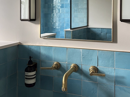 Pared de azulejos de zellige de color azul en un baño 
